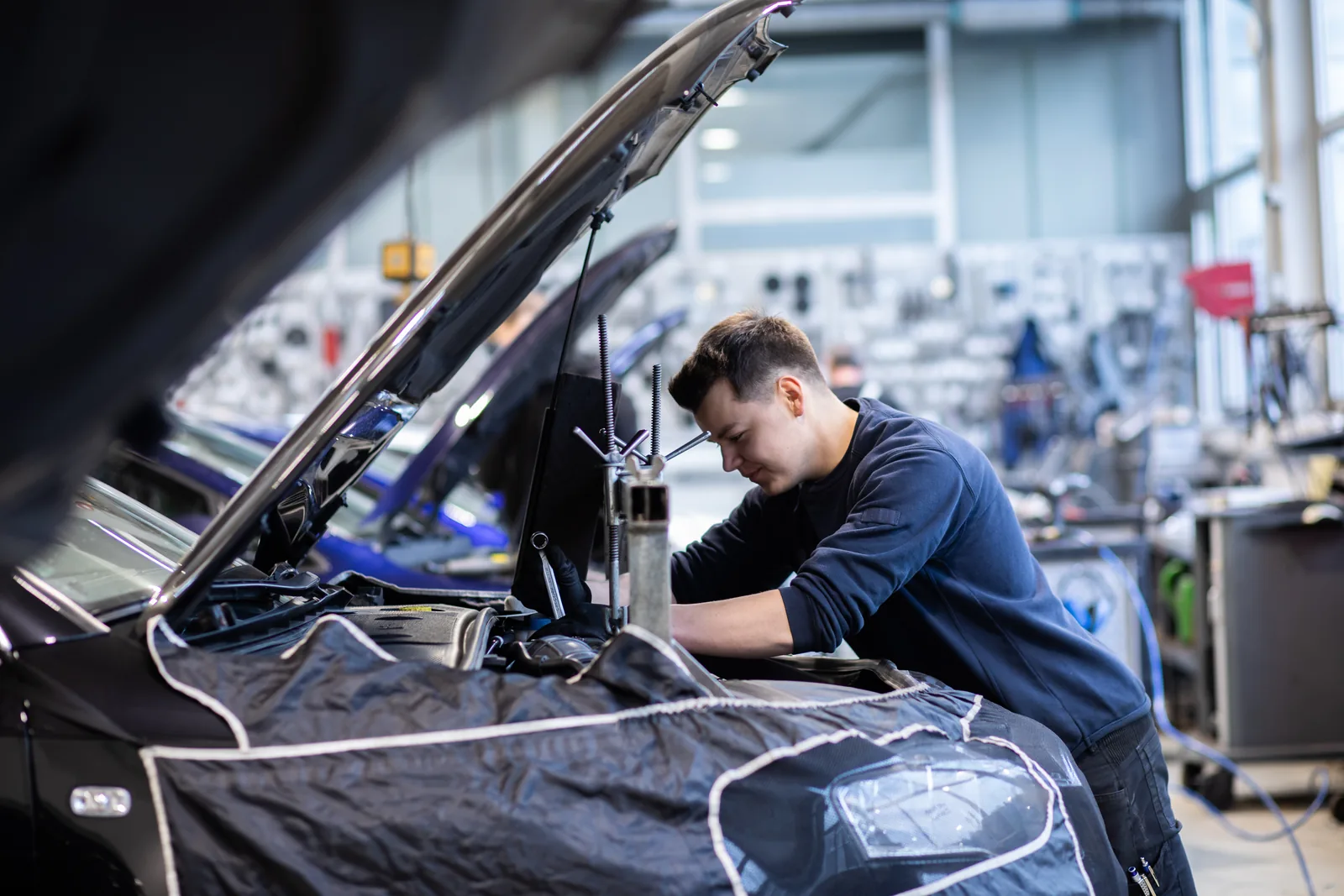 Arbeit am Motorraum eines Fahrzeugs